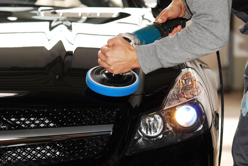 Mécanicien utilisant une polisseuse rotative sur la carrosserie